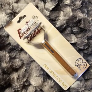 Best Buds dual undercoat rake for dog groomers with wooden handle and metal rake head on gray fur background